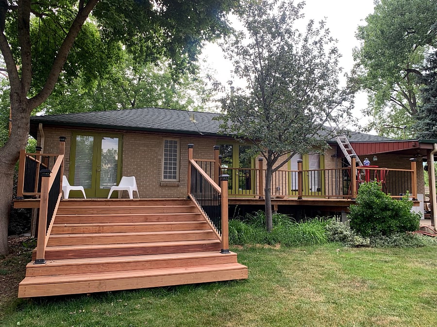 View back of house with deck and stadium stairs. Back of house faces east