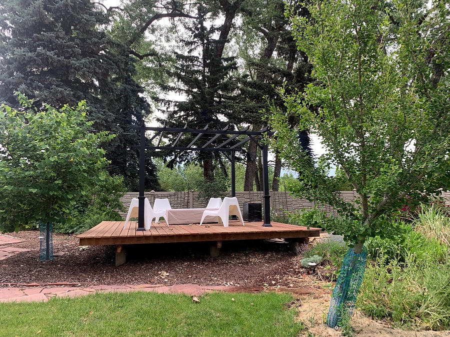 Backyard platform deck with pergola, propane fire pit and deck chairs