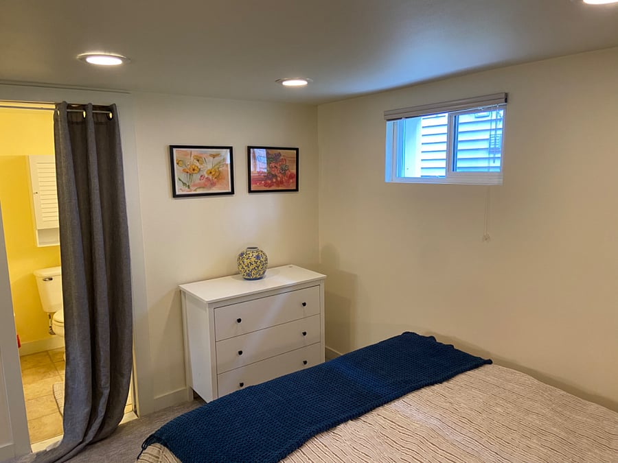 Bed and dresser in bedroom with doorway to bathroom