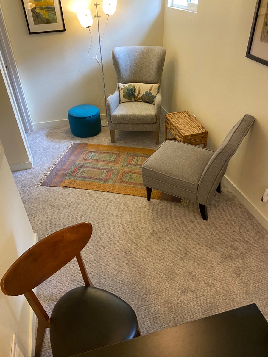 Desk & chair at one end of living room with seating area at the other end