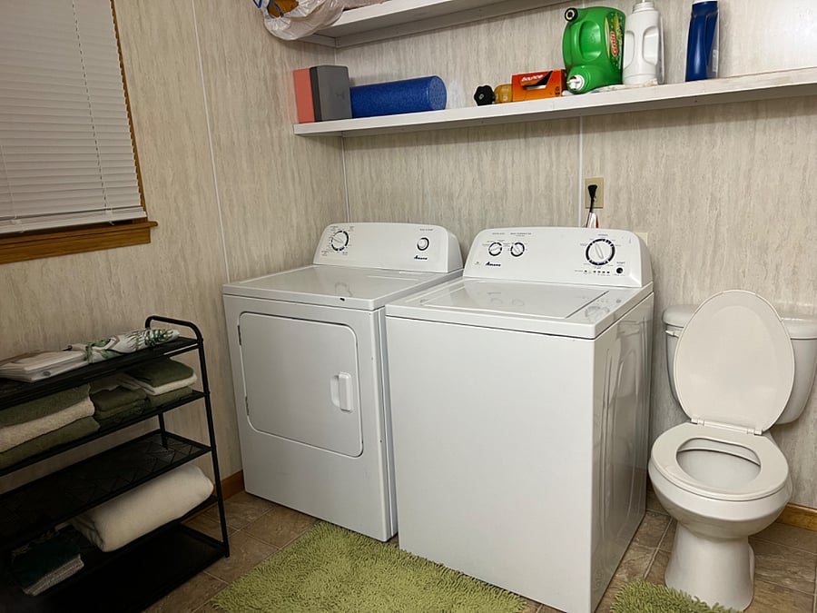 Bathroom and in-unit laundry area washer and dryer.