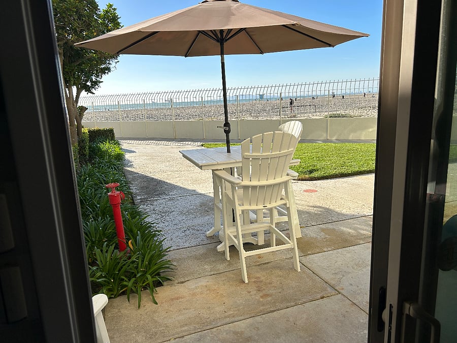 Patio chairs and table with umbrella to enjoy view.