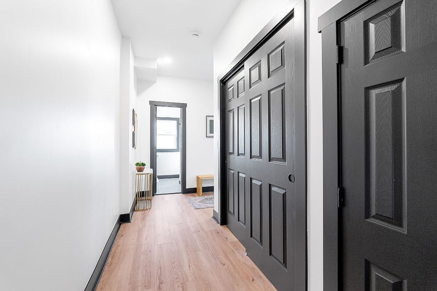 Hallway to large closet for storage, first floor full bathroom, laundry, and back door.