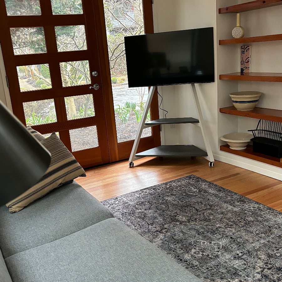 West seating area with built in bookcase. Smart TV on rolling rack for easy movement.