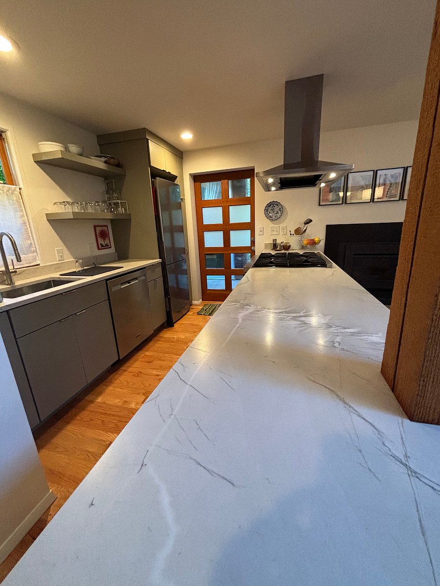 Long stone peninsula counter, custom cabinets. Door to rear patio.