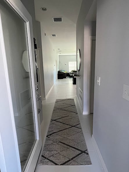 The Entry Hall opens up to a spacious fully-equipped kitchen and relaxing Dining and Living Room area. Off to the right is the Guest Bath and Laundry area with Washer and Dryer. On the left, is the Guest Bedroom and door to the 2-car garage.