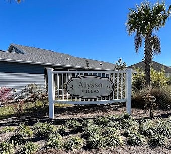 Home is on a corner lot behind and to the left of the entrance to Alyssa Villas.