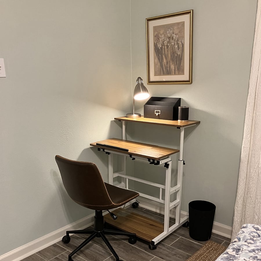 Convenient desk with swivel chair and lamp.
