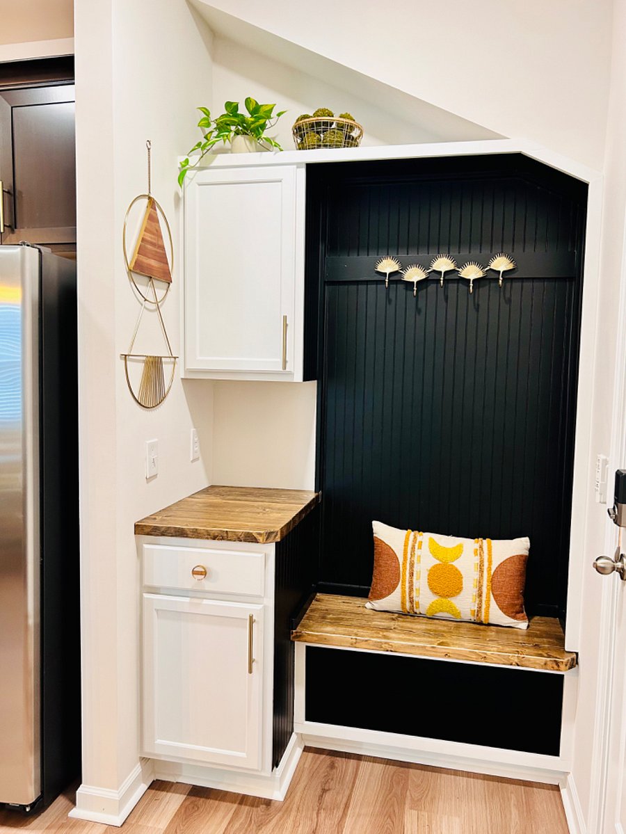 Drop-zone with shoe storage, coat hooks, and extra cabinetry.