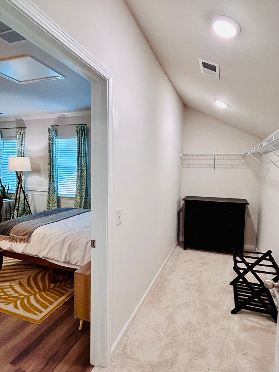 Walk-in closet with dresser and luggage rack.