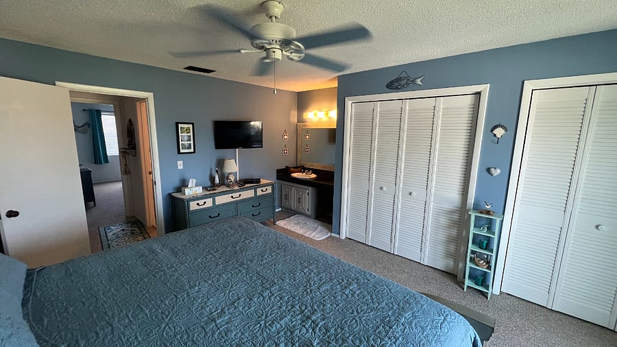 Primary bedroom w/ vanity, sink, TV