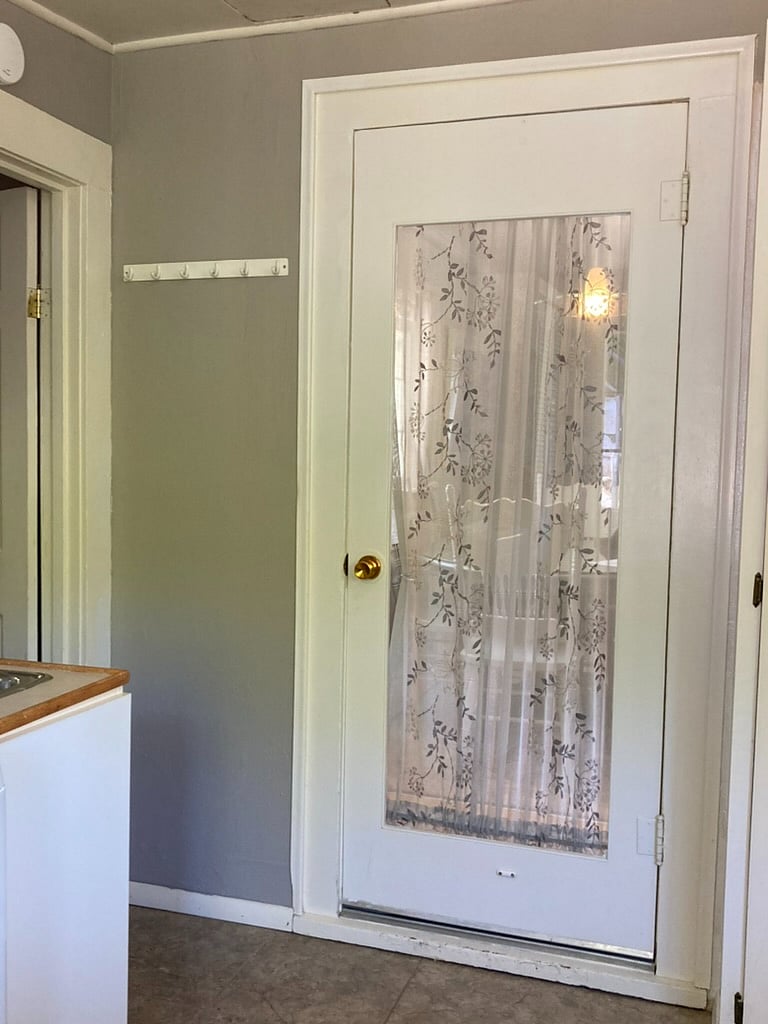 Door from main house into laundry room and back bedroom. Washer and pantry cupboard here.