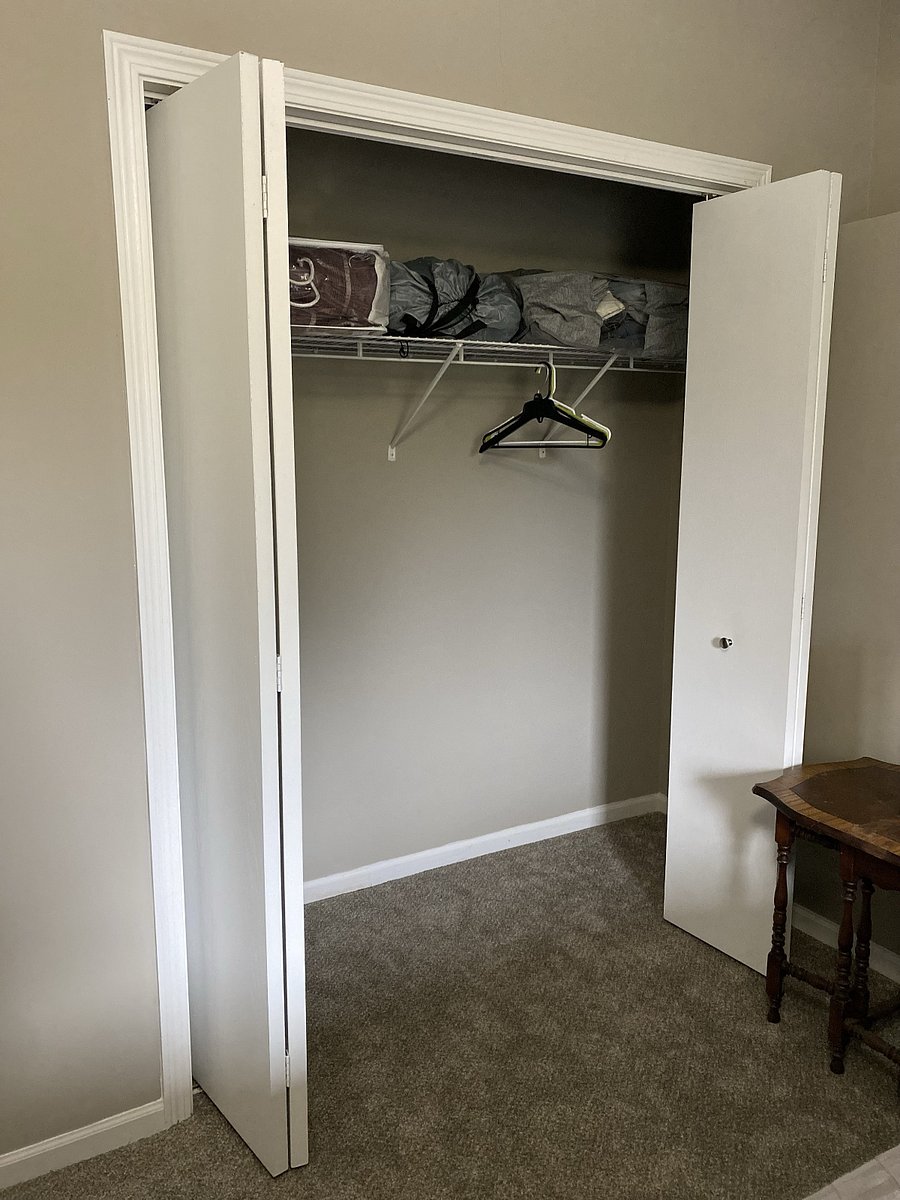 Bedroom 2: closet space with extra blankets and hangers