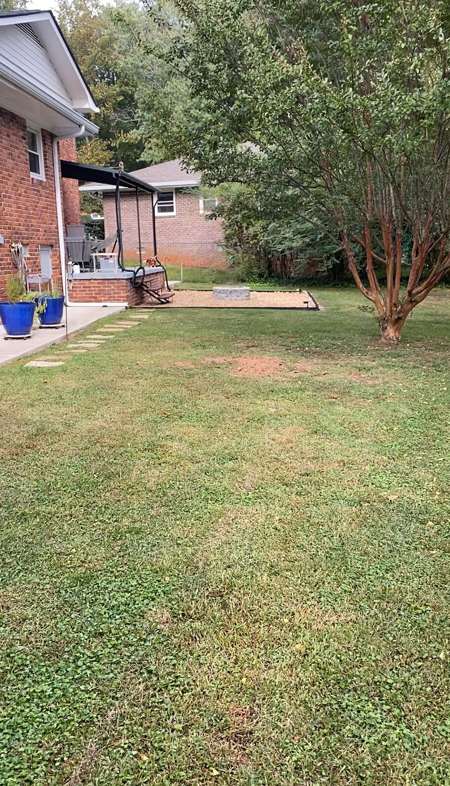 A shot of the backyard, showing the back patio and the firepit.