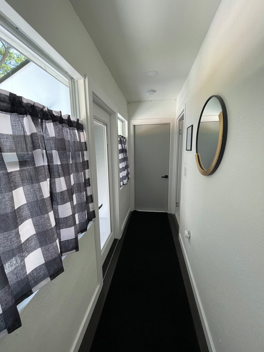 hallway with shared laundry to the right. Other unit is in the front of the home.