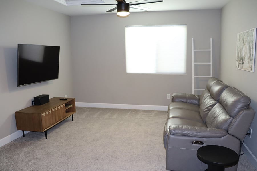 Upstairs living space with gaming console, and electric reclining sofa.
