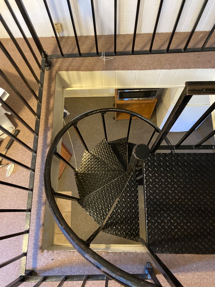 Narrow spiral staircase leads to the attic bedroom.