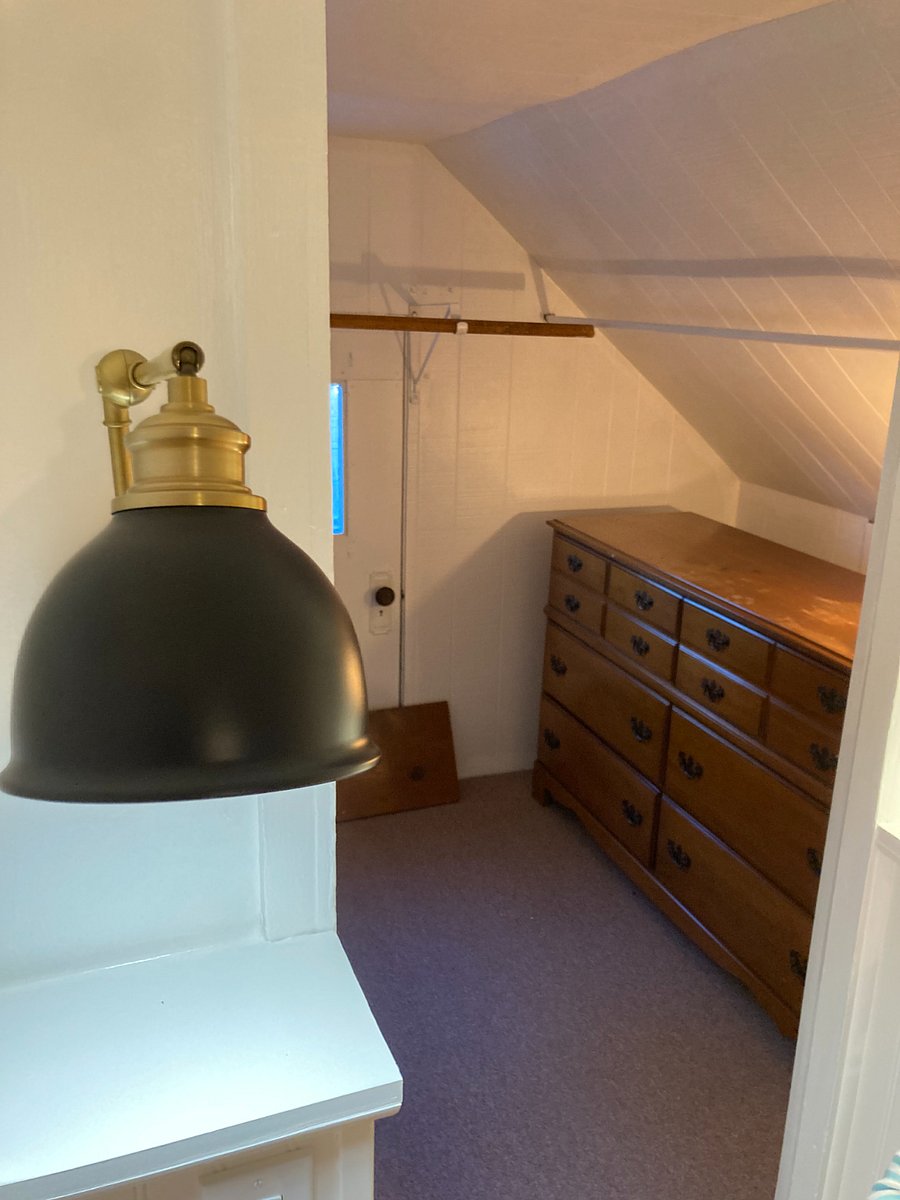 Large closet with a dresser is located at the back of the attic bedroom.