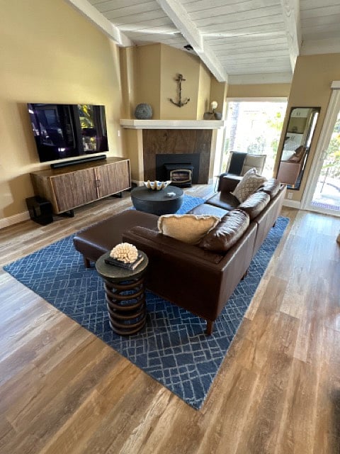 Leather sofa with chaise lounge, 65 inch smart TV with soundbar. Large sitting chair for additional seating against back window.
