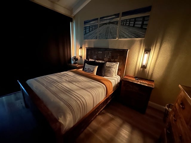 Bedroom with custom shades closed for privacy. Sconces with dim lighting available as well.