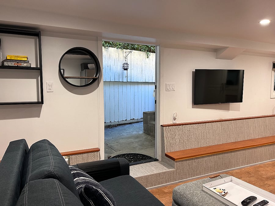 swivel TV wall mounted, window with black out shades to the right of TV 