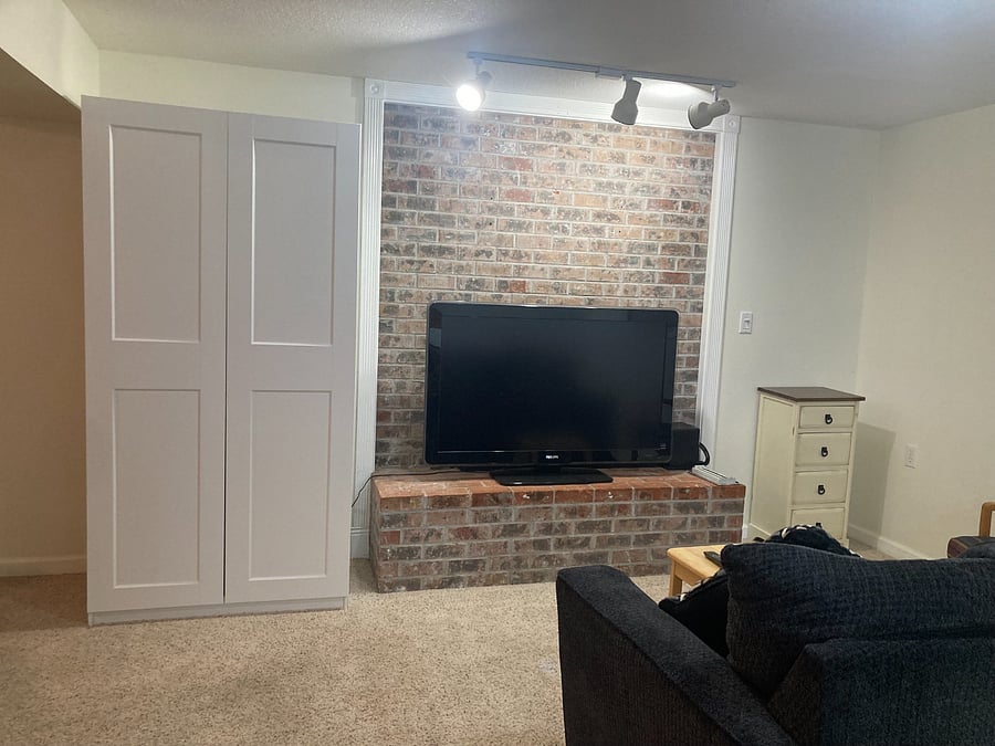 TV with Roku, comfy love seat, and full armoire for your hanging clothes.
