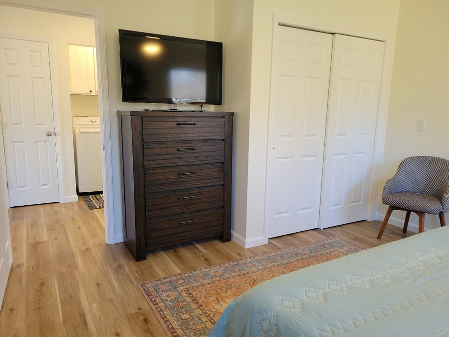 Spacious bedroom with dresser, closet and Roku TV