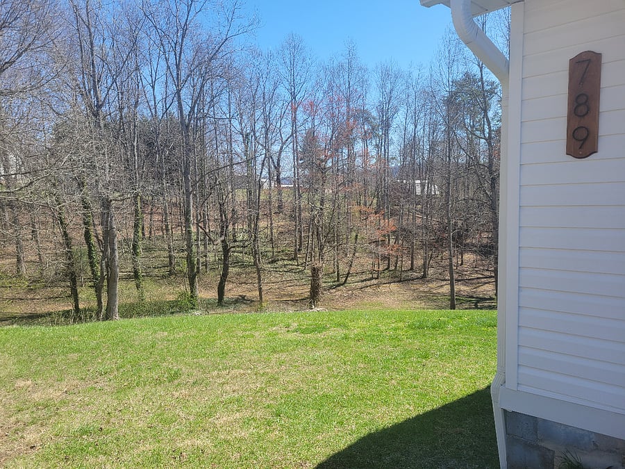Left side of house with lots of privacy in natural setting