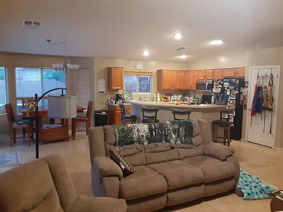 looking at the full kitchen and dining table from the living room, Kitchen has fridge/freezer combo, dish washer, stove with stove top, microwave and garbage disposal, Dining room table has 4 chairs and the island has 4 chairs.