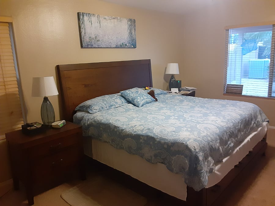 king bed with nightstands on both sides, with 2 large drawers (for a nightstand) each. large window looking out to the backyard. bed also has drawers at the foot of the bed.
