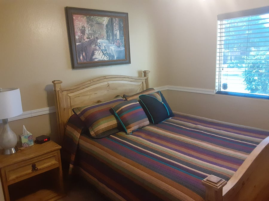 Bedroom on the right as you enter the 2 bedrooms and full bath area. This one looks over the street. Has a nightstand with a drawer and lamp.