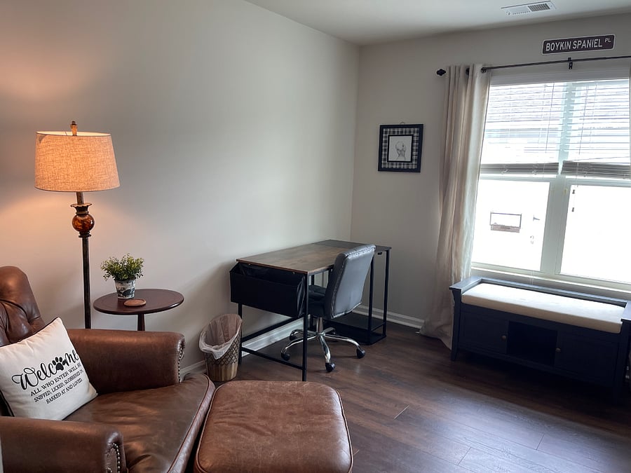 Office w two desks and lovely window w bird feeder.