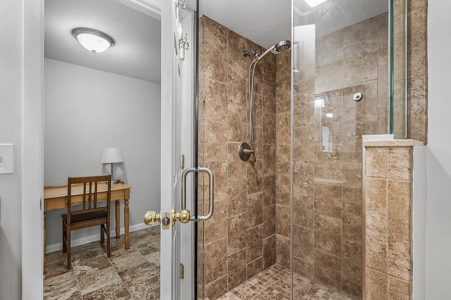 Small desk in area between bathroom and bedroom.