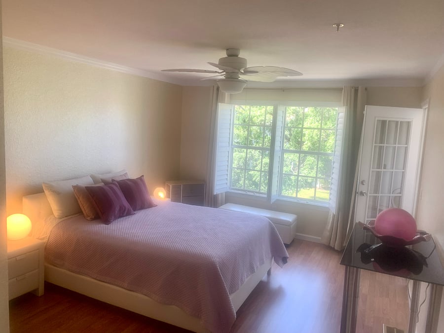 Master bedroom with a view of a pond