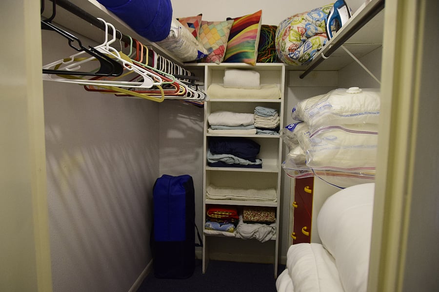 Walk in closet with plenty of bedding.