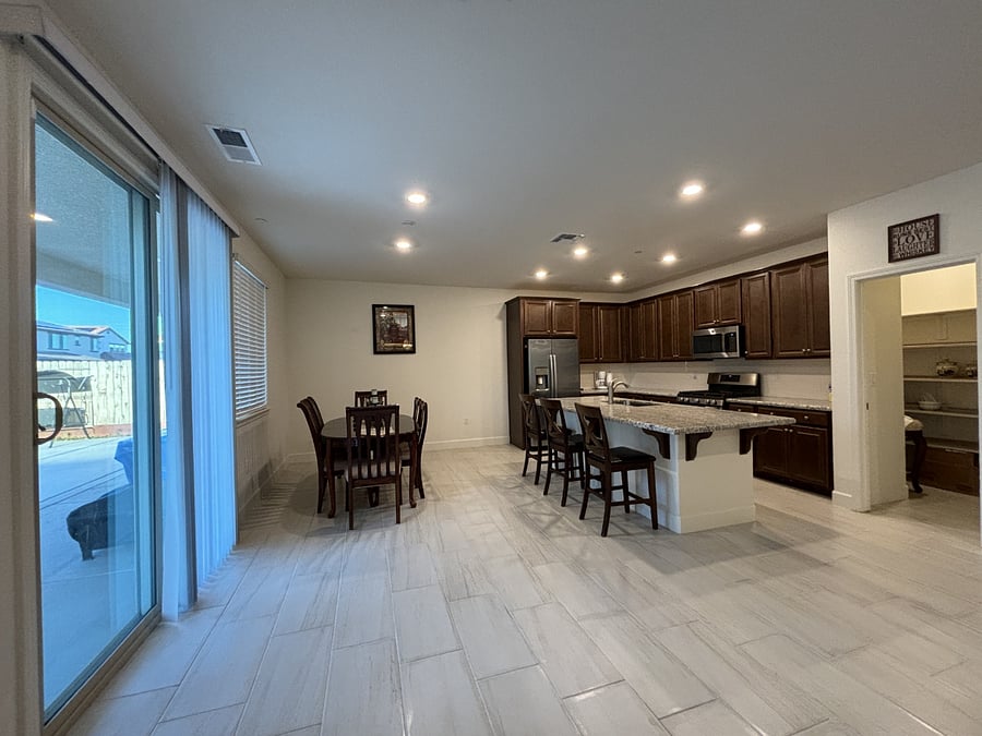 Kitchen with huge walk-in pantry. Sliding door access to the backyard with many fruit trees.