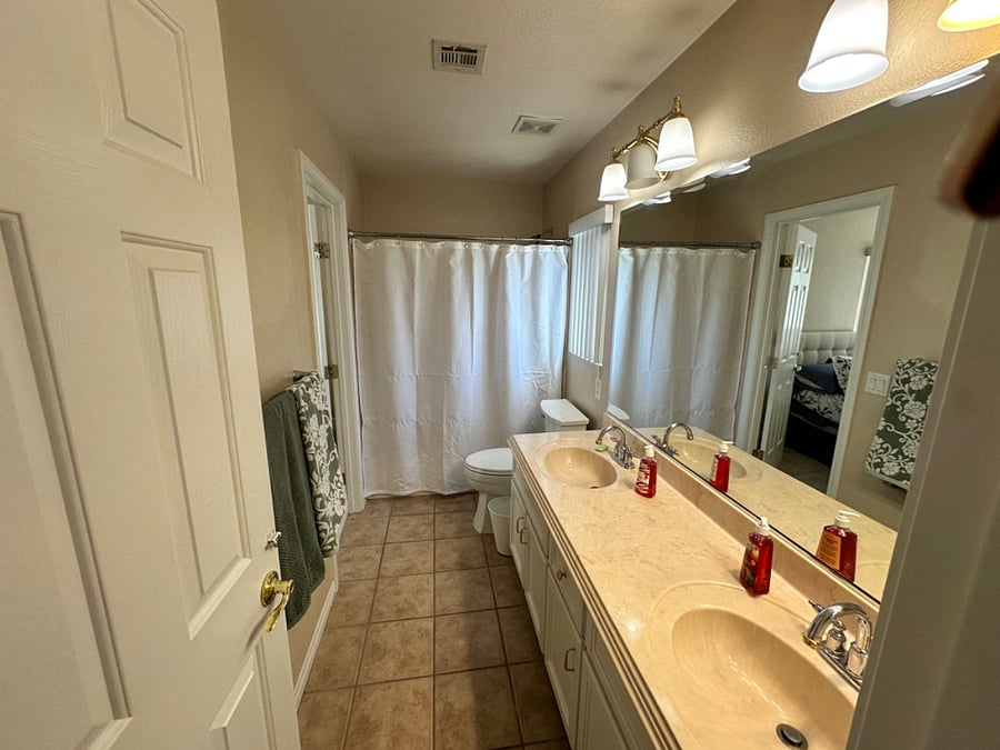 private restroom with dual sinks, tub and shower combo