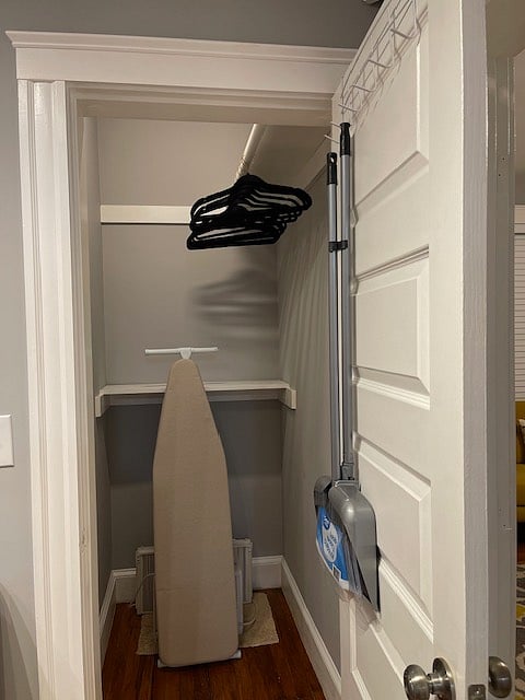 Hallway closet with a full ironing board & iron. Ample storage space