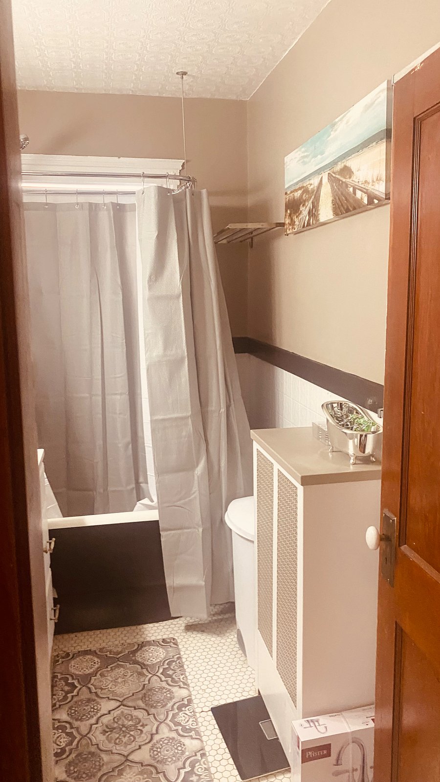Newly painted bathroom with new shower head and large pedestal tub