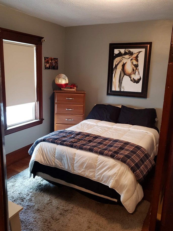 Furnished bedroom with queen size bed, desk and closet