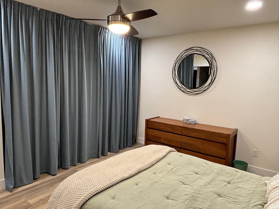 Behind curtains is a wall of closet storage ceiling to floor.
