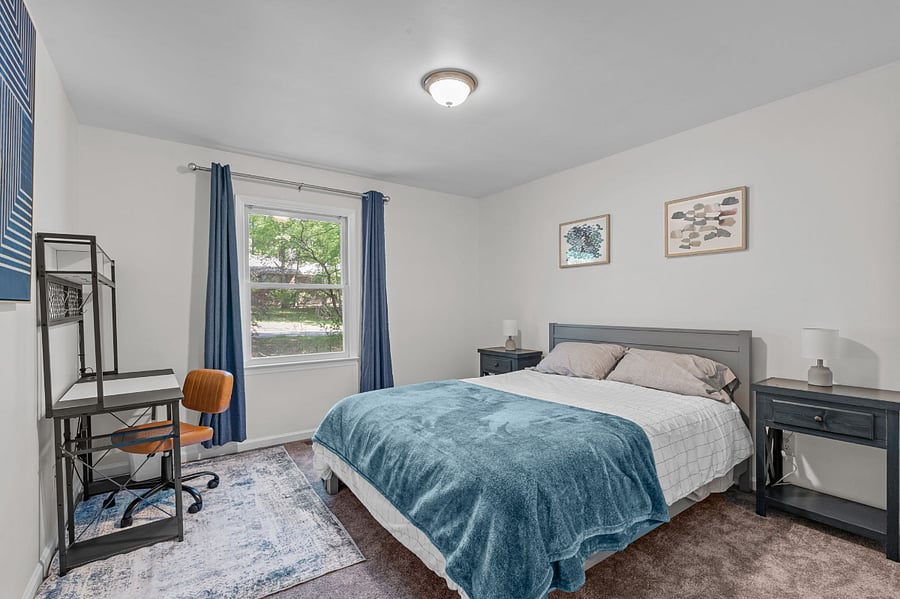 First guest room with a queen size bed, desk, and walk in closet