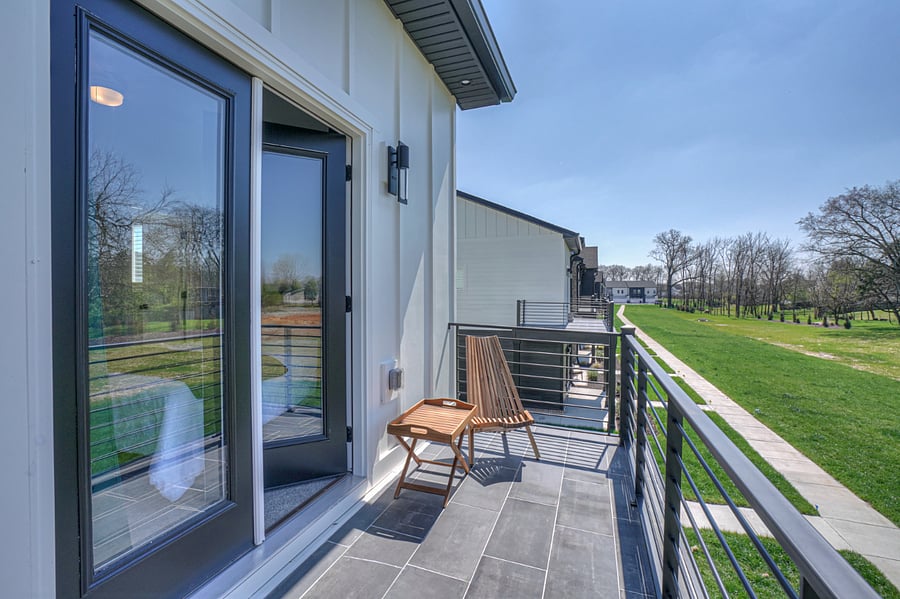 Gorgeous cozy outside deck with 2 chairs overlooking green space and sidewalks