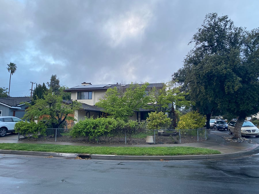Two-story family home with trees and patios and gardens to enjoy.