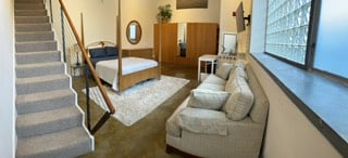 Bedroom. Area below TV can be used as vanity area or work space. Yoga space between beed and closet (back of picture).