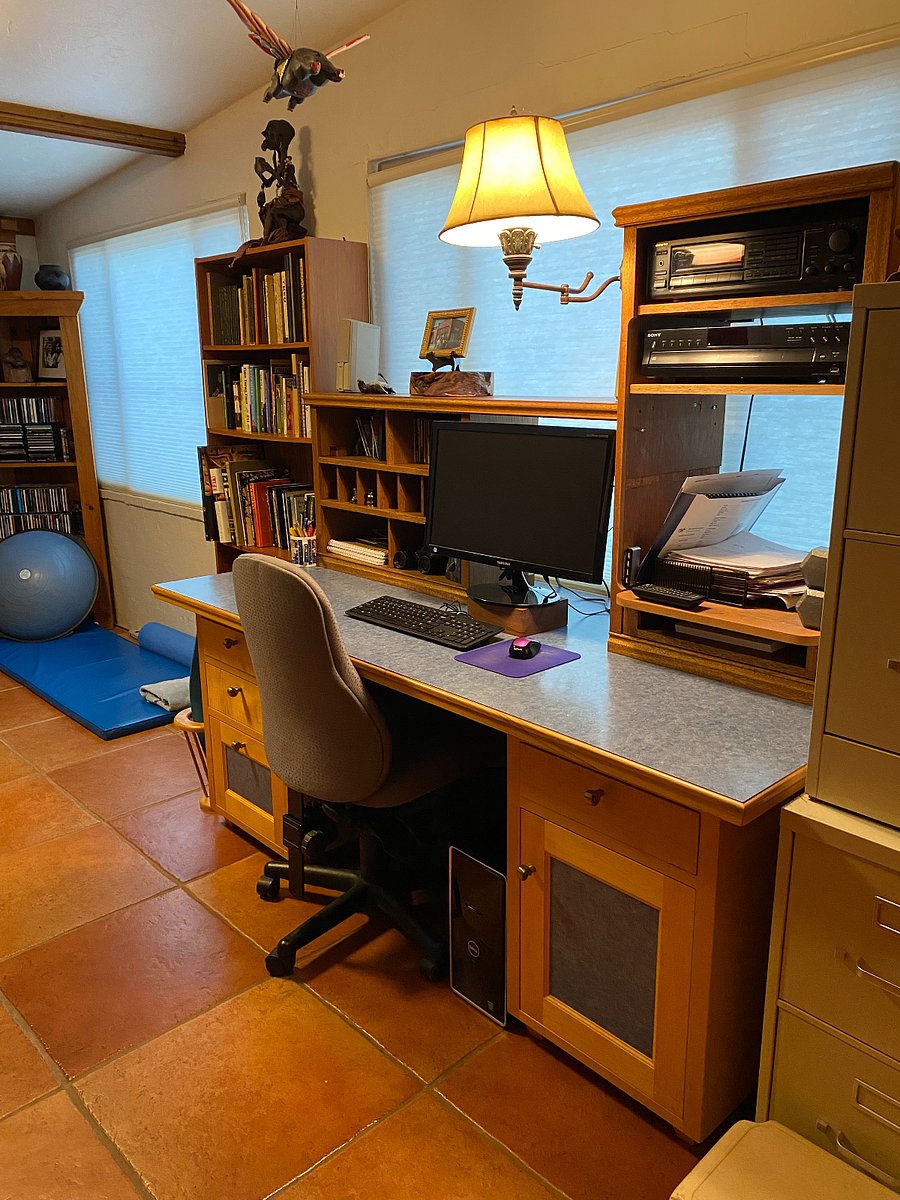 Desk in den with large monitor, mouse, radio/CD player. Speakers are in the living room.