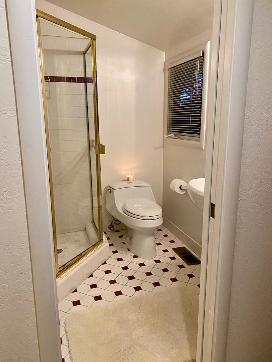 Private bath with shower, sink and cabinets.
