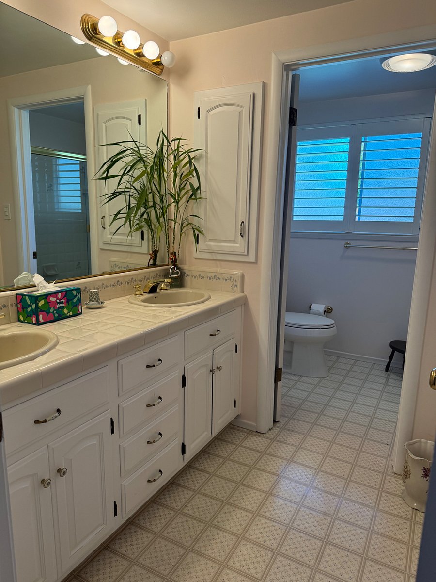 Bathroom with two sinks & separate toilet area.