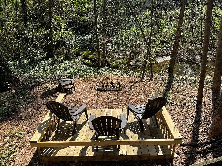 Fire pit area in secluded back yard overlooking stream/waterfall and small pond.