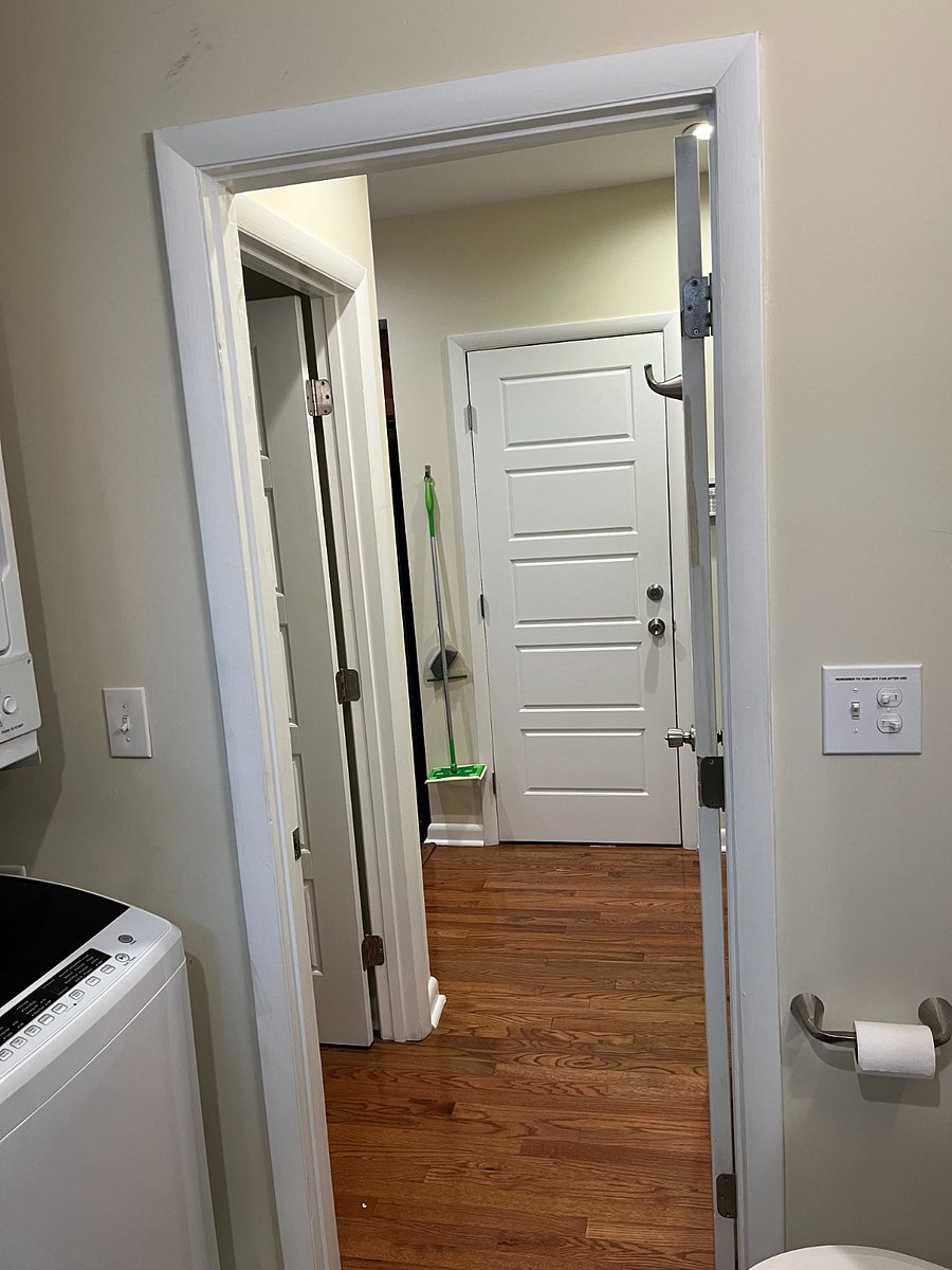 View from bathroom into hallway. Note: the door ahead is closet under stairs and not a point of entry or exit. 